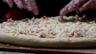 为厨师的手在透明手套，接触未烘焙的披萨在黑色背景，烹饪概念。 框架。 男子